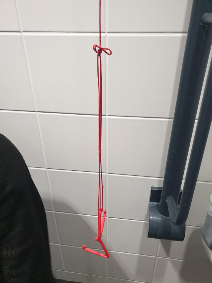 Red emergency cord tied up high off the floor