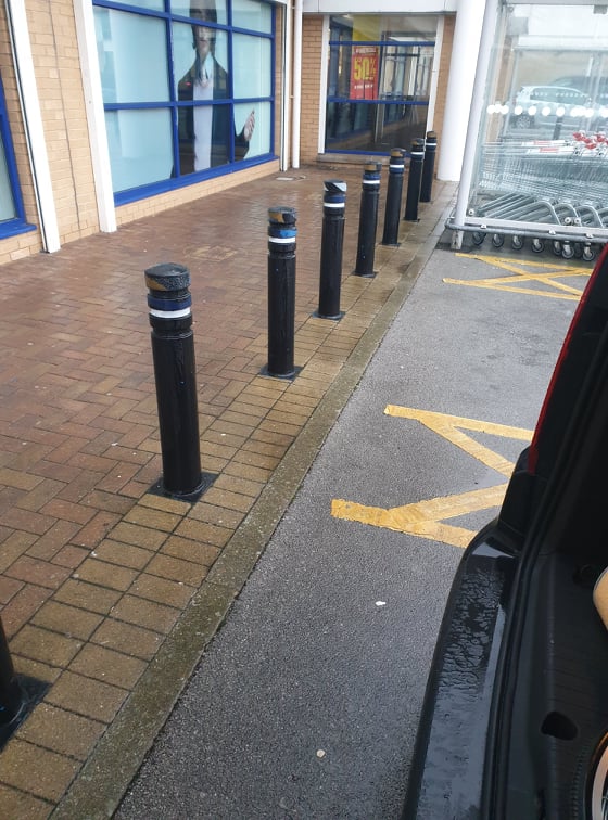 Bollards directly behind car in disabled parking bay