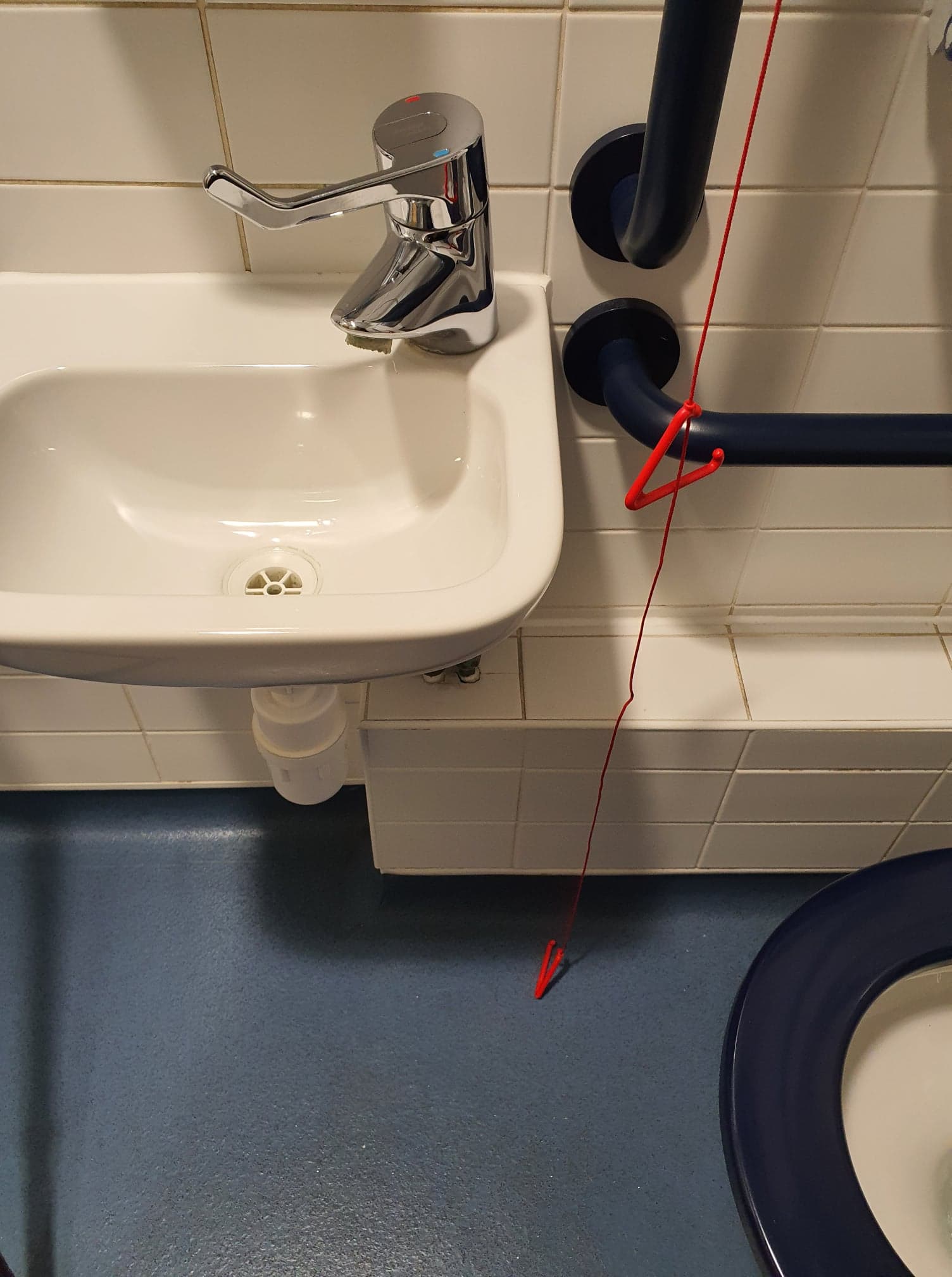 Red emergency cord hanging freely to the floor