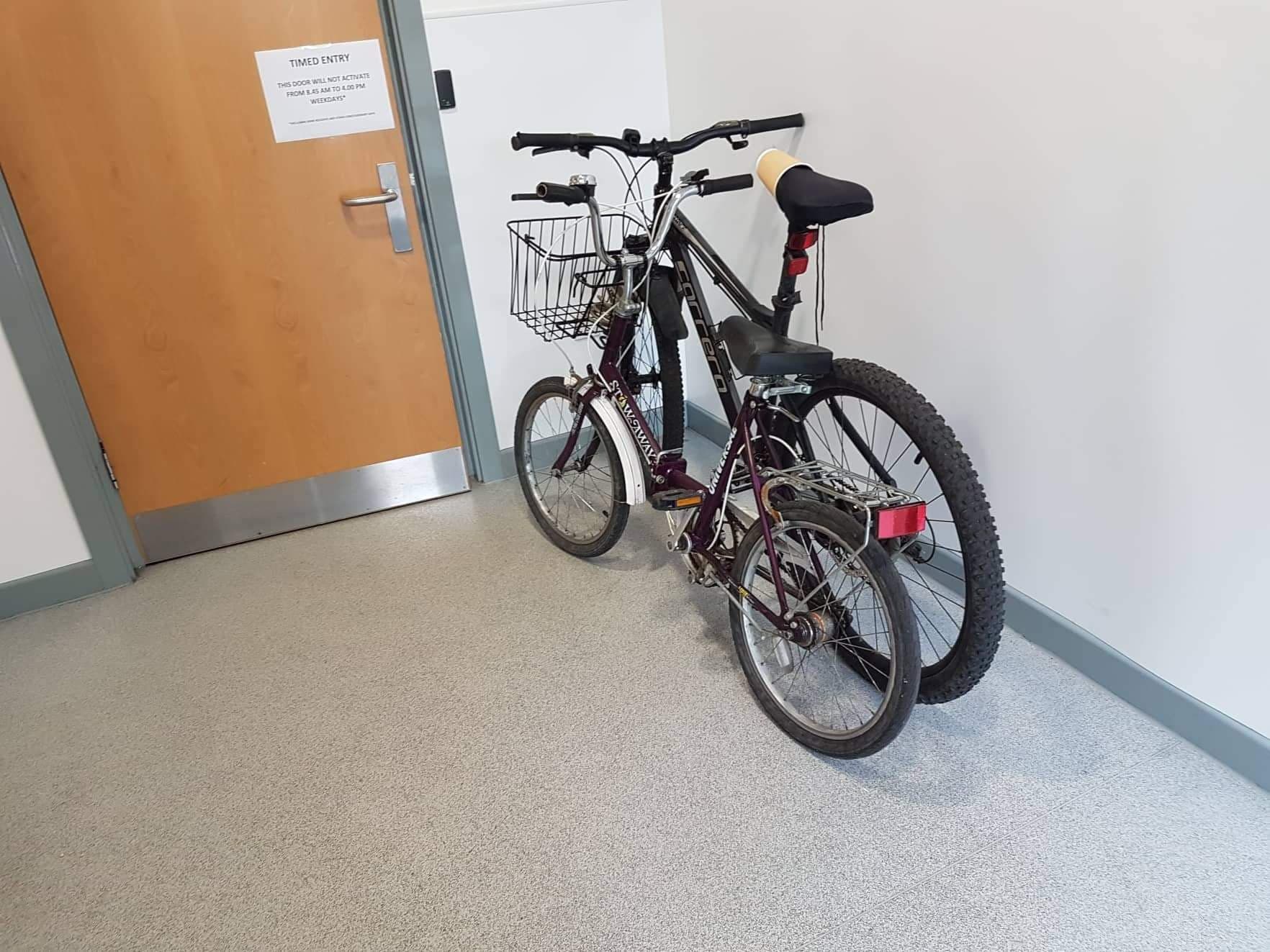 Two bikes in front of out-of-hours door