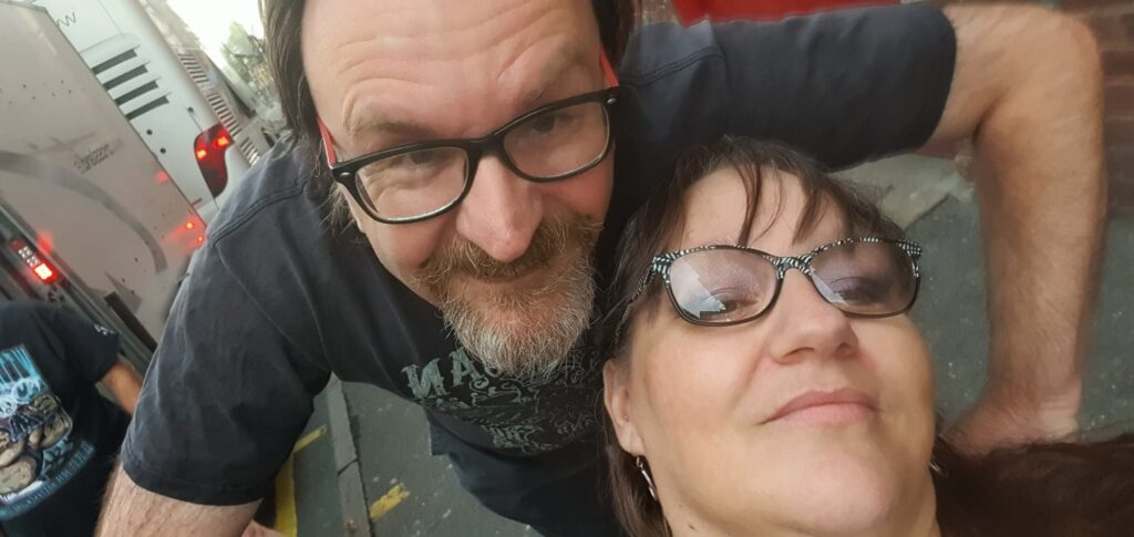 Robin and Helen selfie next to band tour bus