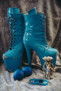 A pair of bright blue, high heeled and hign platform lace up ankle boots