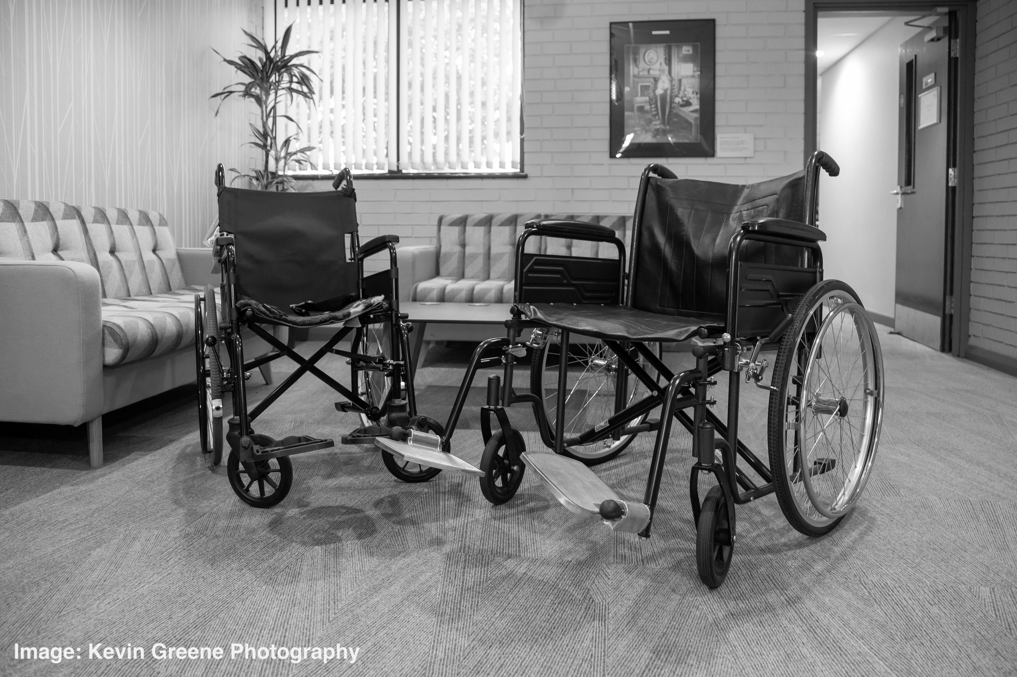 Two wheelchairs side by side in a lobby