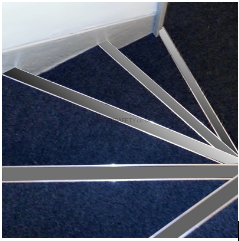 twisting blue carpeted stairs featuring a silver anti-slip stair nosing