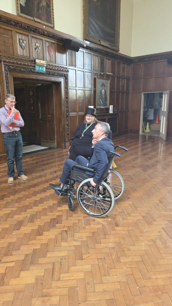 2 wheelchair users and a standing man in deep discussion